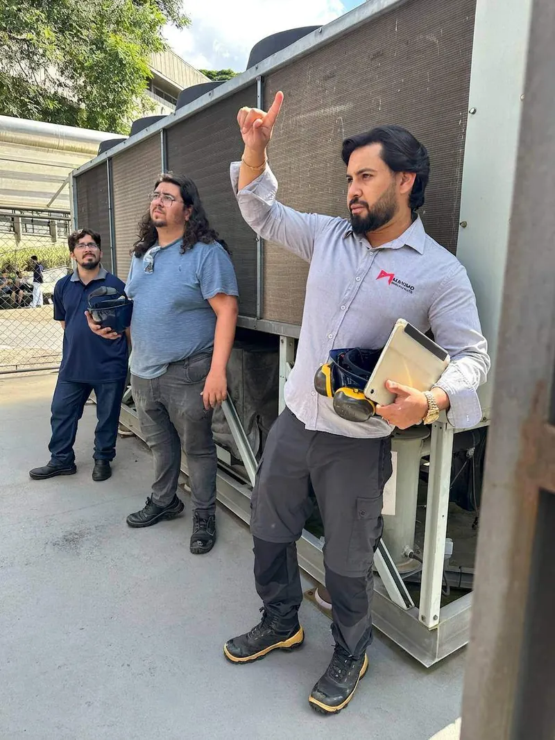 Equipe de engenharia da Máximo Engenharia em visita técnica, analisando um equipamento instalado.
